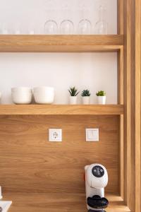a kitchen shelf with bowls and a toaster on it at Oak Studio in Setúbal