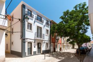 un edificio en una calle con un árbol y coches en Oak Studio, en Setúbal