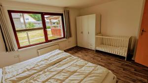 1 dormitorio con cama, ventana y cuna en Happy Hero Reisen Ferienwohnungen auf Usedom nahe Achterwasser, en Krummin