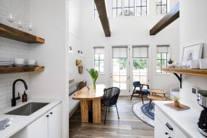 a kitchen with white cabinets and a wooden table at The Station by Compo Hotels in Travelers Rest