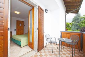 カスティオーネ・デッラ・プレゾラーナにあるMax Meublèのベッド、テーブル、椅子が備わる客室です。