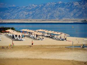 a beach with a bunch of umbrellas and a body of water at Apartmani Fulir in Vrsi