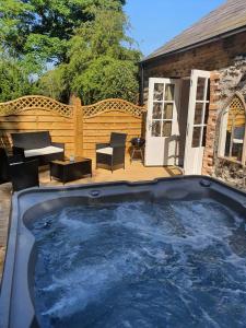 a large hot tub sitting on a patio at Hare Cottage in Ballymena