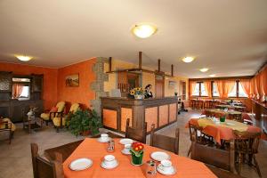 uma sala de estar com mesas e cadeiras e uma cozinha em Max Meublè em Castione della Presolana