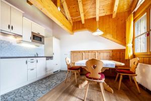 a kitchen with a table and chairs in a room at Mitterbruggehof Apt Berganemone in Anterselva di Mezzo