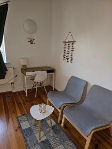 een woonkamer met 2 stoelen en een tafel bij Surf Inn in Klaipėda