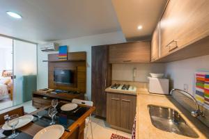 cocina con 2 lavabos y TV en una habitación en Loft no Posto Seis, Copacabana, en Río de Janeiro