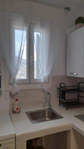 a kitchen counter with a sink and two windows at Magda house in Livadi +34 photos
