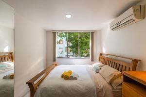 un dormitorio con una cama con dos animales de peluche en Loft no Posto Seis, Copacabana, en Río de Janeiro