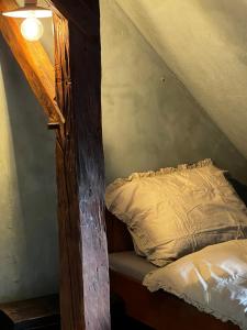 a bed in a attic with a wooden beam at Banícka chalupa U felčiara in Banská Bystrica