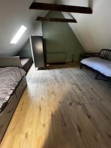 an attic room with two beds and a wooden floor at Banícka chalupa U felčiara in Banská Bystrica