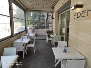 um restaurante com mesas e cadeiras brancas e uma janela em HOTEL HOUSE GARGANO em San Giovanni Rotondo