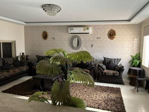 ein Wohnzimmer mit einem Sofa und einer Palme in der Unterkunft ليلتنا in Ha'il
