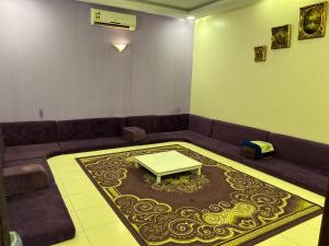 ein Wohnzimmer mit einem Sofa und einem Tisch auf einem Teppich in der Unterkunft ليلتنا in Ha'il