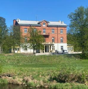 un gran edificio de ladrillo sentado en la cima de un campo en Hotel Montagne, en Åmmeberg