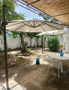 a patio with a table and an umbrella at Casa Azzurra in Conca Specchiulla