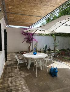 a table and chairs under an umbrella on a patio at Casa Azzurra in Conca Specchiulla