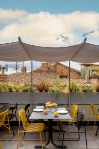 a table and chairs on a patio with a canopy at Hotel Priori Secret Garden in Perugia