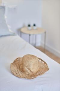 un sombrero de paja sentado en la parte superior de una cama en Hotel del Mar, en Sanxenxo