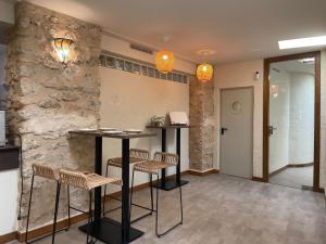 Habitación con mesa, sillas y pared de piedra. en Alkalea Hospedería, en Alcalá del Júcar