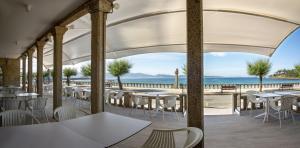ein Restaurant mit Tischen und Stühlen und Meerblick in der Unterkunft Hotel del Mar in Sanxenxo