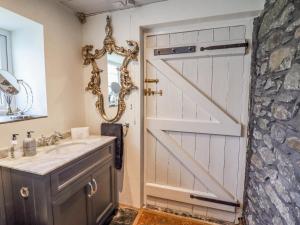 a bathroom with a barn door and a sink at Neuadd Wen in Derwen +31 photos