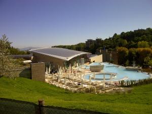 a large swimming pool with chairs and a building at Agriturismo Casa Rossa in Chianciano Terme