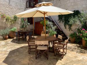 een tafel en stoelen met een parasol op een patio bij Villa Saint George Stone Costa Demetriou in Kathikas