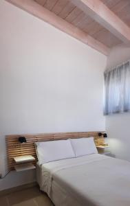 una camera da letto con un grande letto bianco e una finestra di A Staccia a Ragusa