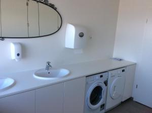 een badkamer met een wastafel en een wasmachine bij Við Hafið Guesthouse in Ólafsvík +37 foto's