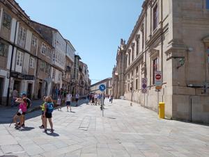 a group of people walking down a city street at Pelamios Catedral in Santiago de Compostela