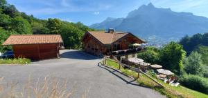 a large wooden building with a mountain in the background at SUPERBE DEMI CHALET LUXUEUX 120M² 8 Personnes à SALLANCHES. in Sallanches