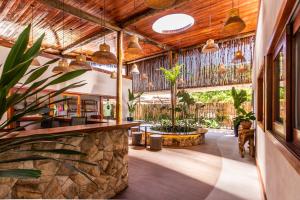 une terrasse intérieure avec des plantes en pot et des plafonds en bois. dans l'établissement Vila Vagalume, à Trairi
