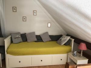 een bed met kussens in een kamer bij Le Perce Neige - plein centre in Luchon