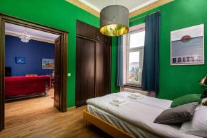 um quarto verde com uma cama e uma janela em Les Couleurs na Cracóvia