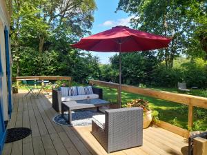 a patio with a table and an umbrella at La Clairière du Seignanx in Saint-Martin-de-Seignanx