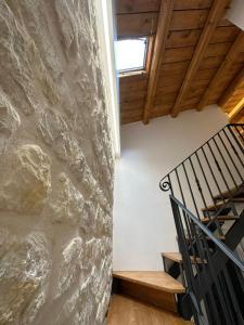 - un escalier dans une chambre dotée d'un mur en pierre dans l'établissement IL RIFUGIO BAROCCO, à Modica