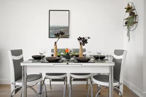 a white dining room table with chairs and a white wall at Ideal Lodgings In Urmston in Urmston