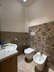 a bathroom with a toilet and a bidet and a sink at IL RIFUGIO BAROCCO in Modica +17 photos