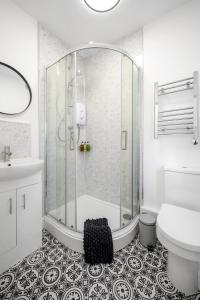 a bathroom with a shower and a toilet and a sink at Ideal Lodgings In Urmston in Urmston