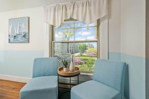 duas cadeiras azuis e uma mesa em frente a uma janela em Waters View Inn em South Haven
