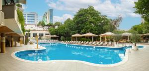 a large swimming pool with chairs and umbrellas at Best Western Plus Congress Hotel Yerevan in Yerevan