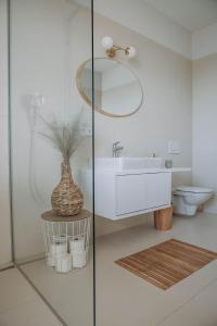 a bathroom with a sink and a toilet and a mirror at ANKERPUNKT Seeblick 