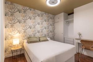 a bedroom with a white bed and a wall at Victorooms in Bilbao