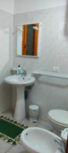W łazience znajduje się umywalka, toaleta i lustro. w obiekcie Il Villino della Nonna w mieście Arbus
