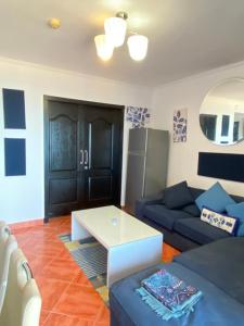 uma sala de estar com um sofá azul e uma mesa em شاليه في بورتو مارينا الساحل الشمالي العلمين 22 em El Alamein