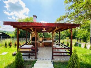 a wooden gazebo in the middle of a yard at Pensiunea Valea Veveritelor in Curtea de Argeş