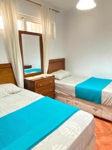 um quarto com duas camas e um espelho em شاليه في بورتو مارينا الساحل الشمالي العلمين 22 em El Alamein