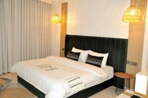 um quarto com uma cama grande e uma cabeceira preta em مساكن الدار 10 em Abha