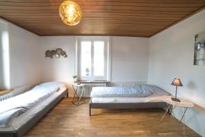 1 dormitorio con 2 camas y techo de madera en Tilia Apartments, en Uster